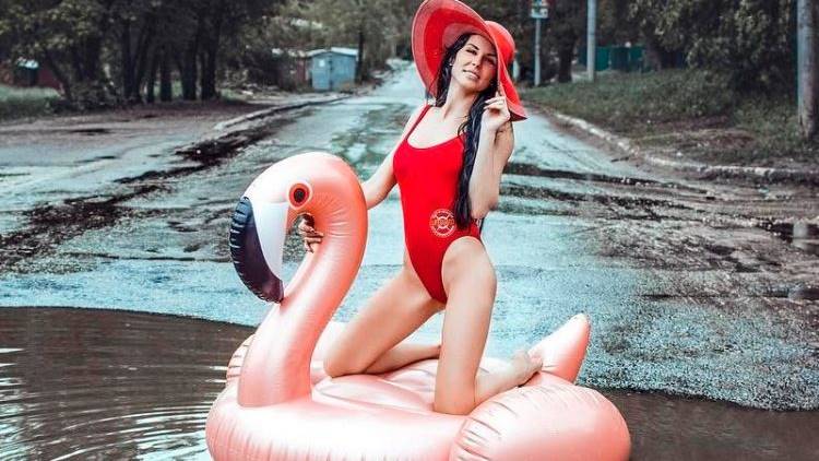นางแบบสาวรัสเซีย แต่งชุดว่ายน้ำไปถ่ายรูปกับบ่อน้ำขัง ประชดสภาพถนนที่ไม่แก้ไขเสียที