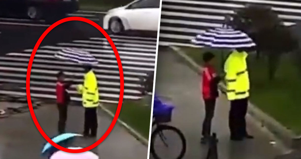 ชาวเน็ตชื่นชม หนุ่มน้อยชาวจีน พยายามกลางร่มให้คุณตำรวจ ที่ยืนทำหน้าที่ท่ามกลางสายฝน